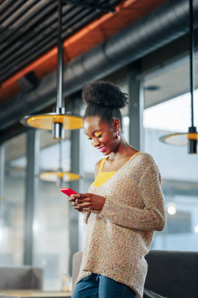 istock Woman wearing sweater with open shoulder reading message on phone 1097506040
