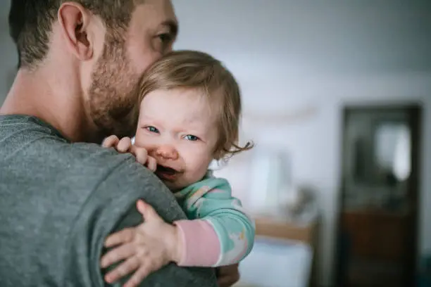 Photo of Father Holding Infant Sick With Cold Virus