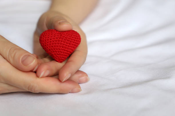 istock Red knitted heart in female hands 1097509082