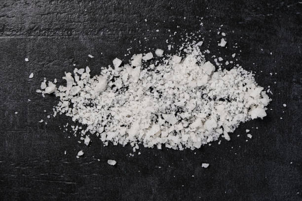 istock Sea flake salt on black background top view 1097511690