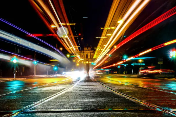A long exposure shot of the maximilianstreet in munich, germany, with the lights of the cars and trams and the parliament of bavaria in the back