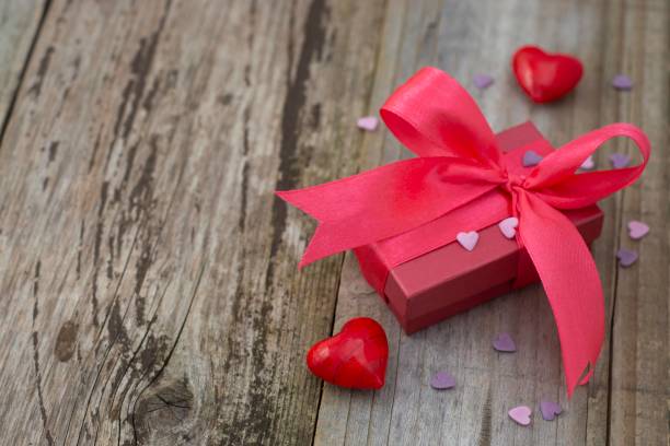 istock Red, pink gift box with big bow, on old wooden table. Top view with place for text. 1097521416