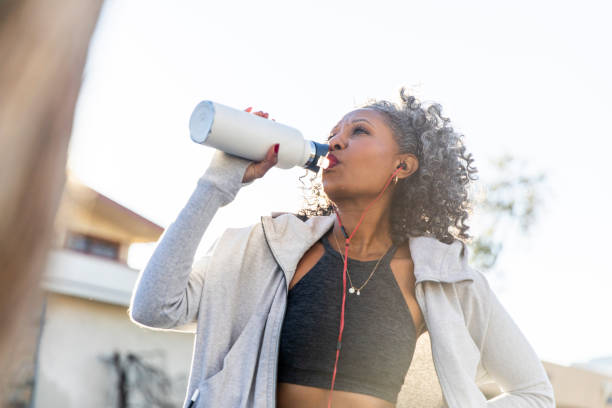 istock Black Woman Taking a Drink of Water while Working Out 1097541768