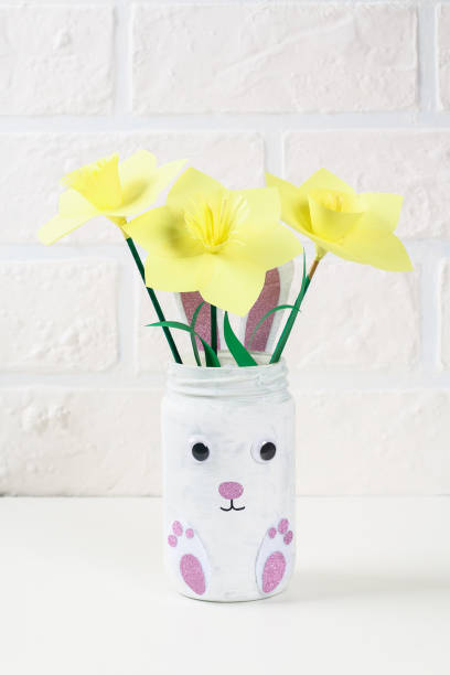 istock DIY Easter vase bunny from glass jar, felt, googly eyes on a green background 1097541950