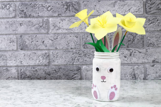 istock DIY Easter vase bunny from glass jar, felt, googly eyes on a green background 1097541978