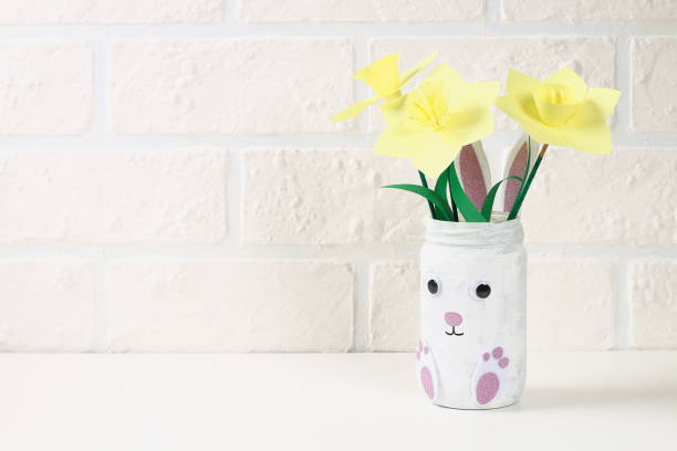 istock DIY Easter vase bunny from glass jar, felt, googly eyes on a green background 1097542010