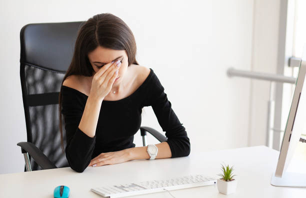 istock Head pain. Exhausted young woman feeling pain in head after working on computer. Overwork concept 1097543754