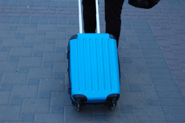 istock A blue traveling suitcase is taken along the path. 1097550440