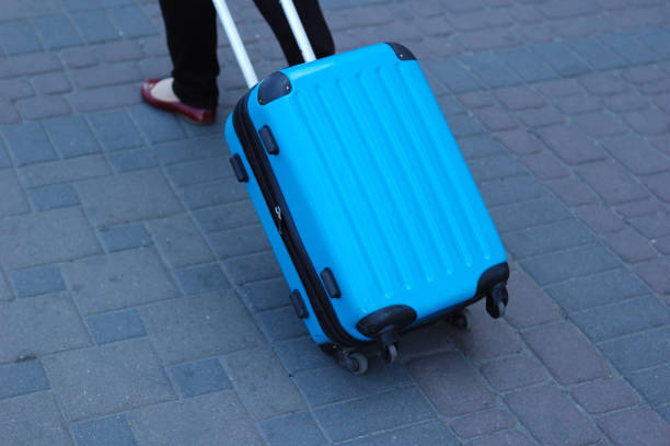 istock A blue traveling suitcase is taken along the path. 1097552038