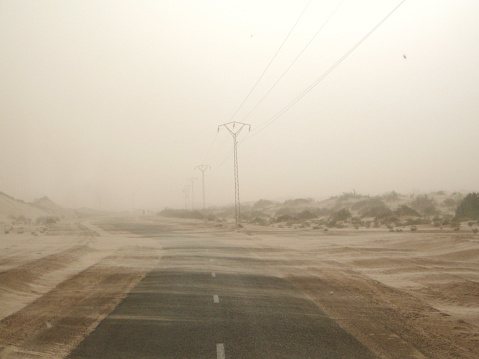 Road next to the Sahara desert during a sandstorm