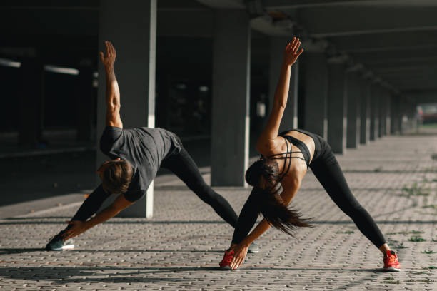 istock Young couple stretching legs in urban environment 1097558066