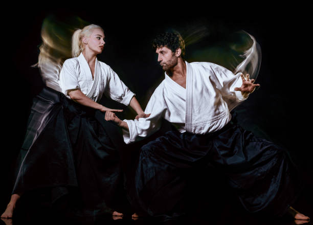 istock Aikido budokas man and woman isolated black background 1097563802