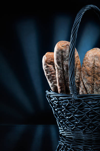 wicker basket with bread on black bacground.