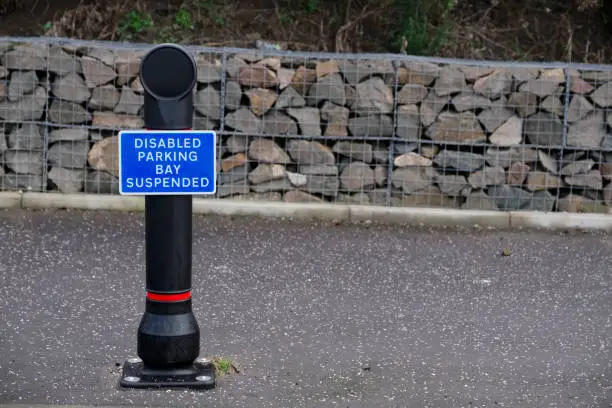 Disabled badge holders only at car park sign post suspended bay uk