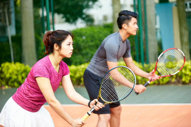 tenistas asiáticos en un partido de dobles mixto - tennis couple women men fotografías e imágenes de stock