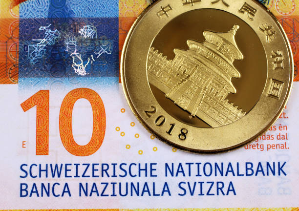 Ten Swiss Franc note with a Chinese gold panda coin stock photo
