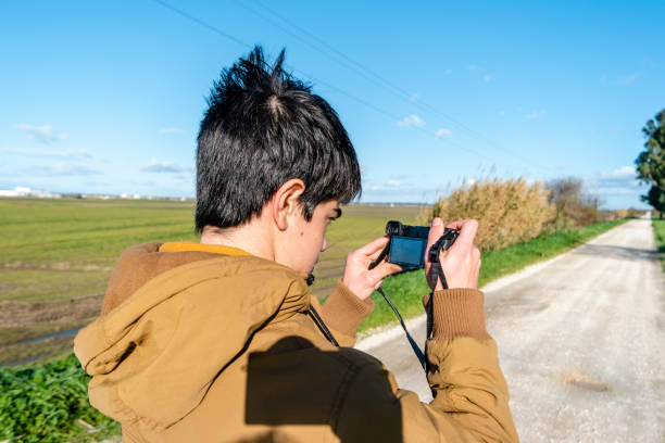 istock young man taking picture on natural background. 1097580640