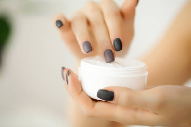 istock Cream for face or body in white container on female hands 1097582540