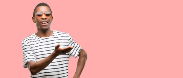 istock African black man wearing sunglasses holding something in empty hand 1097582976