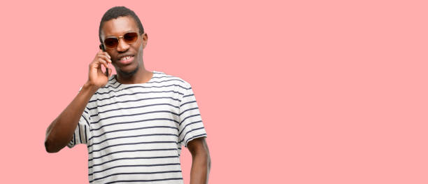 istock African black man wearing sunglasses happy talking using a smartphone mobile phone 1097583186