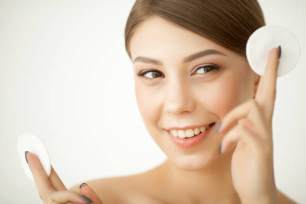 istock Beautiful young woman is cleaning her face 1097583884
