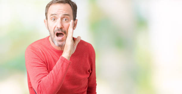 istock Handsome middle age hoary senior man wearing winter sweater over isolated background hand on mouth telling secret rumor, whispering malicious talk conversation 1097586826