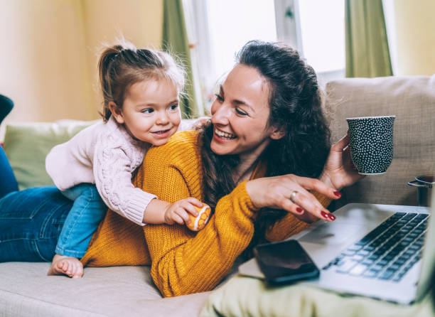 母と娘の楽しいオンライン - family indoors happiness laughing ストックフォトと画像