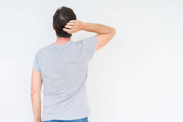 istock Handsome senior man over isolated background Backwards thinking about doubt with hand on head 1097593118