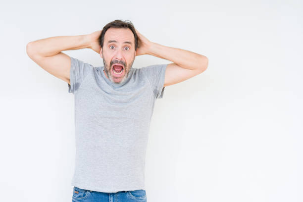 istock Handsome senior man over isolated background Crazy and scared with hands on head, afraid and surprised of shock with open mouth 1097593178