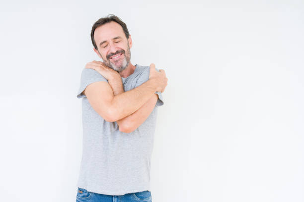 istock Handsome senior man over isolated background Hugging oneself happy and positive, smiling confident. Self love and self care 1097593196