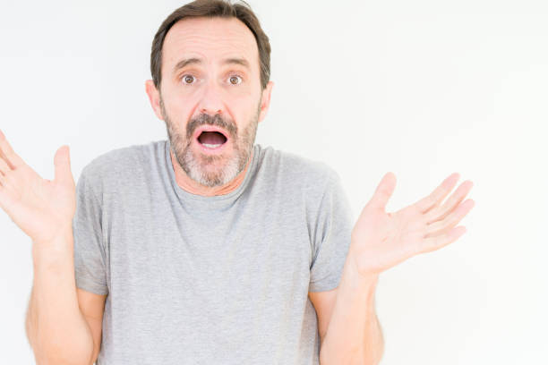 istock Handsome senior man over isolated background clueless and confused expression with arms and hands raised. Doubt concept. 1097593332