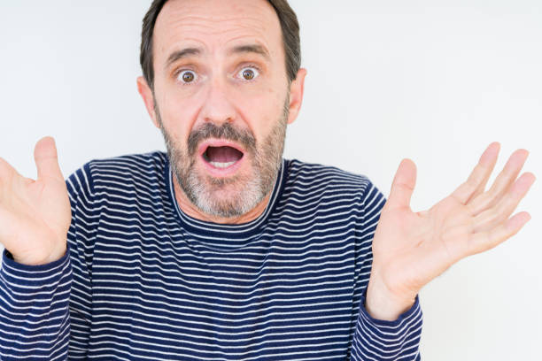 istock Handsome senior man over isolated background clueless and confused expression with arms and hands raised. Doubt concept. 1097593444