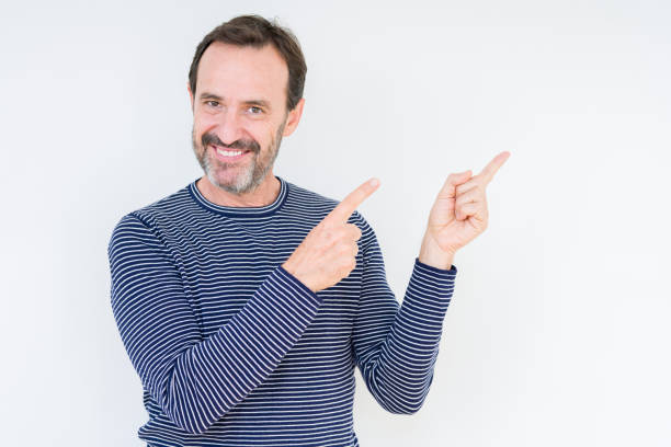 istock Handsome senior man over isolated background smiling and looking at the camera pointing with two hands and fingers to the side. 1097593516