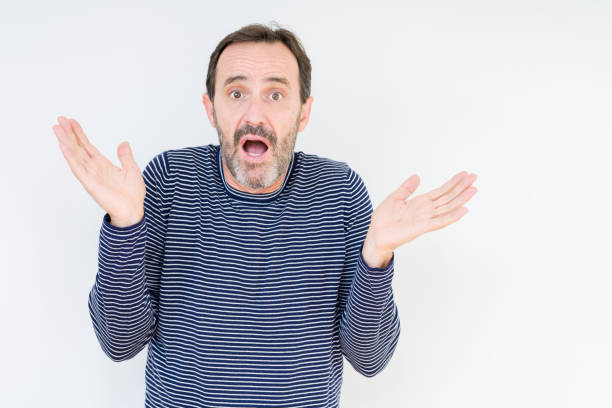istock Handsome senior man over isolated background clueless and confused expression with arms and hands raised. Doubt concept. 1097593524