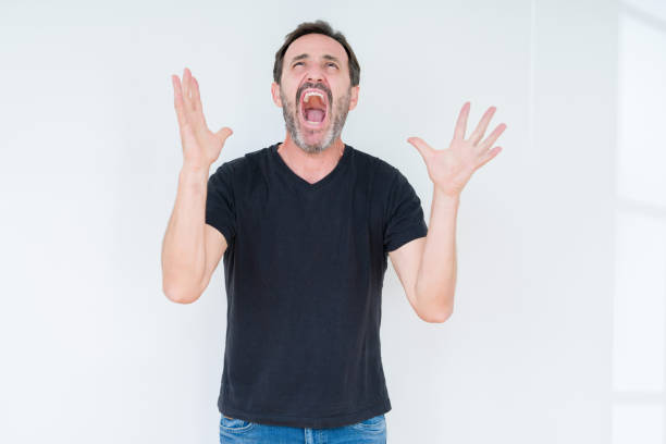 istock Senior man over isolated background crazy and mad shouting and yelling with aggressive expression and arms raised. Frustration concept. 1097594208
