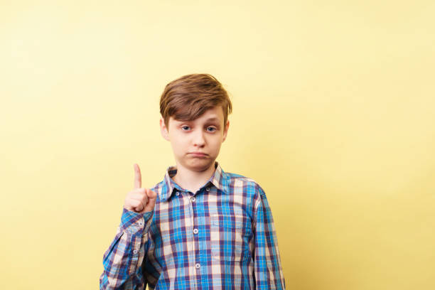 istock look there. boy pointing upwards with index finger 1097600886
