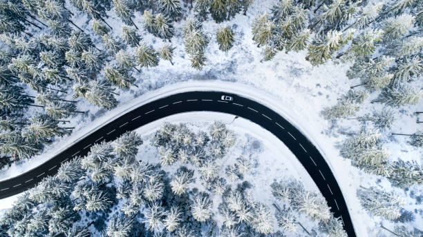 istock Road through the wintery forest - aerial view 1097603122