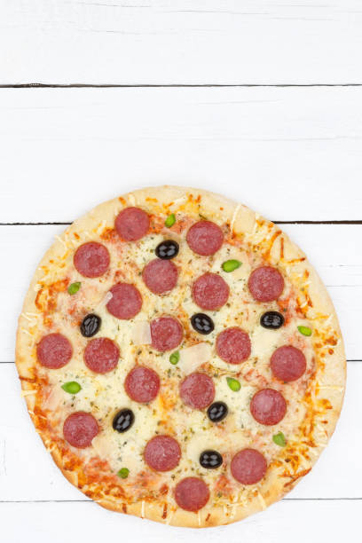 istock Pizza pepperoni salami copyspace copy space portrait format from above on wooden board 1097605332