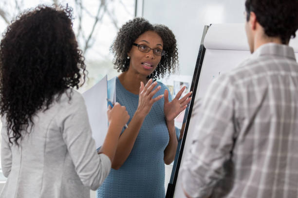 istock Serious businesswoman explains plan to coworkers 1097606052