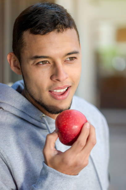 istock Young latin man eating apple fruit runner winter portrait format running sports training fitness 1097610336
