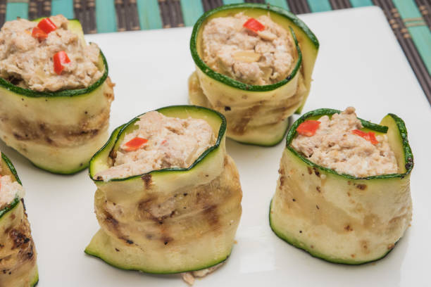 Grilled zucchini rolls with curd cheese and tuna on plate. Top view with copy space