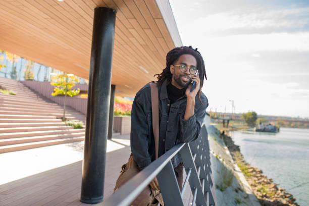 istock Smiling man talking on a mobile phone outdoors 1097614104