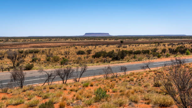 istock Distant view of mount Conner with Lasseter highway in NT central outback Australia 1097627414