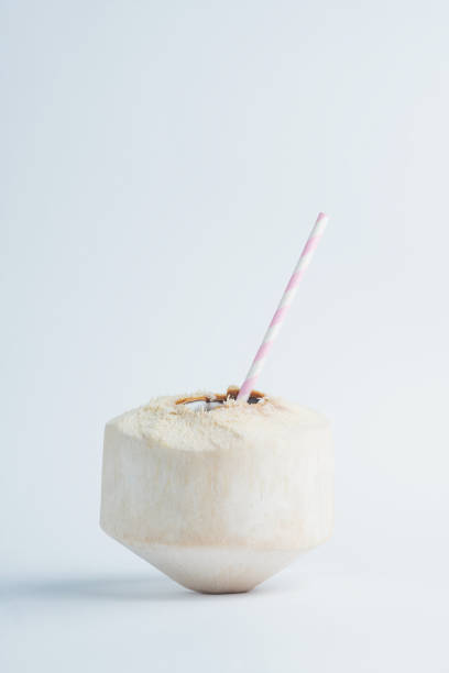 istock Freshly cut juicy coconut with a straw inside on white background. 1097630928