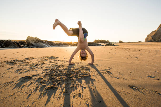 Boys play on the beach in Santa Barbara, doing yoga, handstands, and walking along the tide pools at sunset.