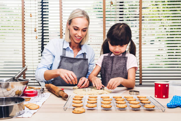 istock Mother and daugthter having fun cooking togather and learning to make a cake while baking in kitchen at home 1097634354