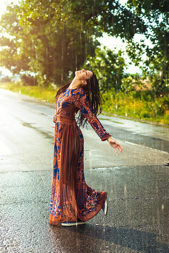 Young woman dancing in the rain