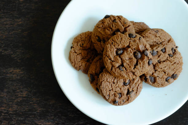 istock Close up Chocolate cookies in white dish on dark wooden table. 1097639276