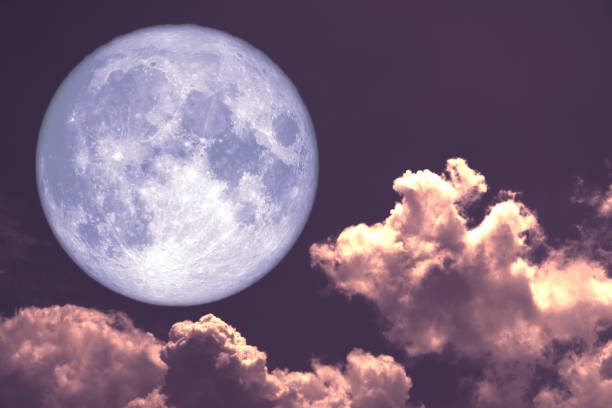 istock worm moon back on silhouette heap cloud on sunset sky 1097646258