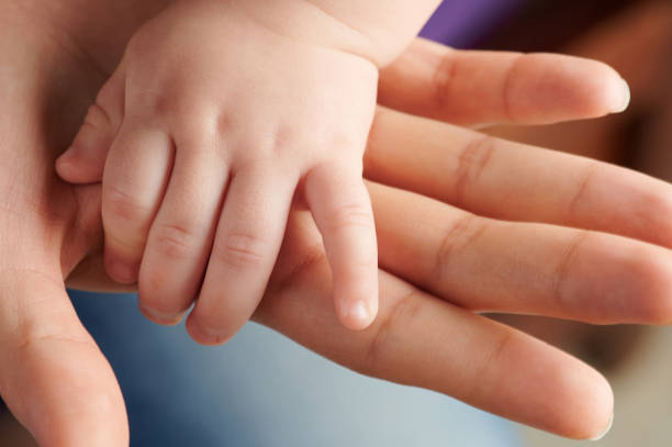 istock Small baby hand on mom palm 1097648420